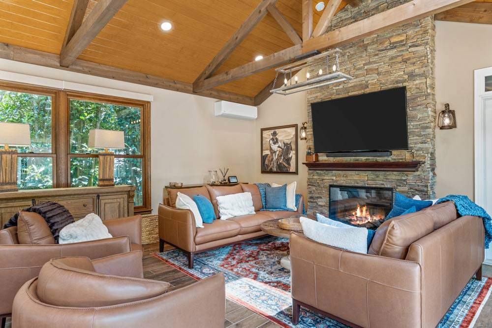 A Custom Sunroom Featuring a Stone Fireplace, Flat-Screen TV, and Leather Seating in North Atlanta