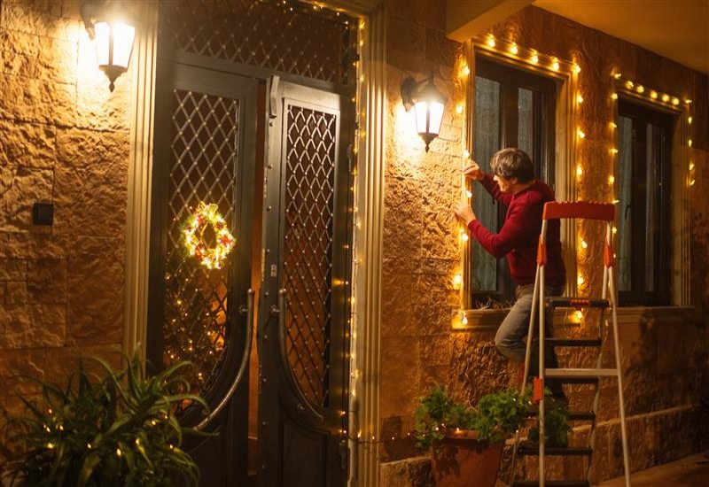 A team member from Exterior Design + Decks is installing outdoor lighting in North Atlanta
