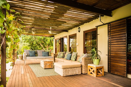 A wooden covered porch featuring outdoor living space with wicker furniture in North Atlanta